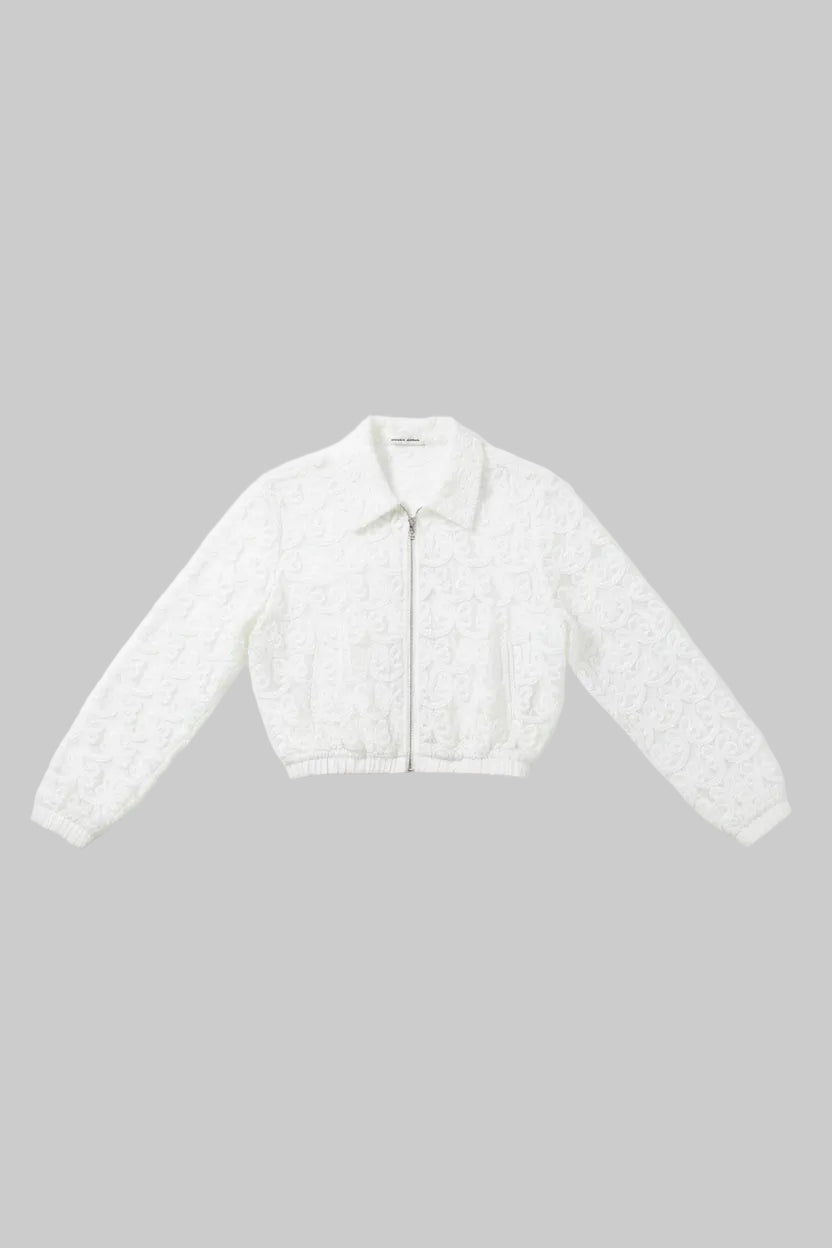 White lace cropped jacket with a front zipper and pointed collar, laid flat on a gray wood-look floor.