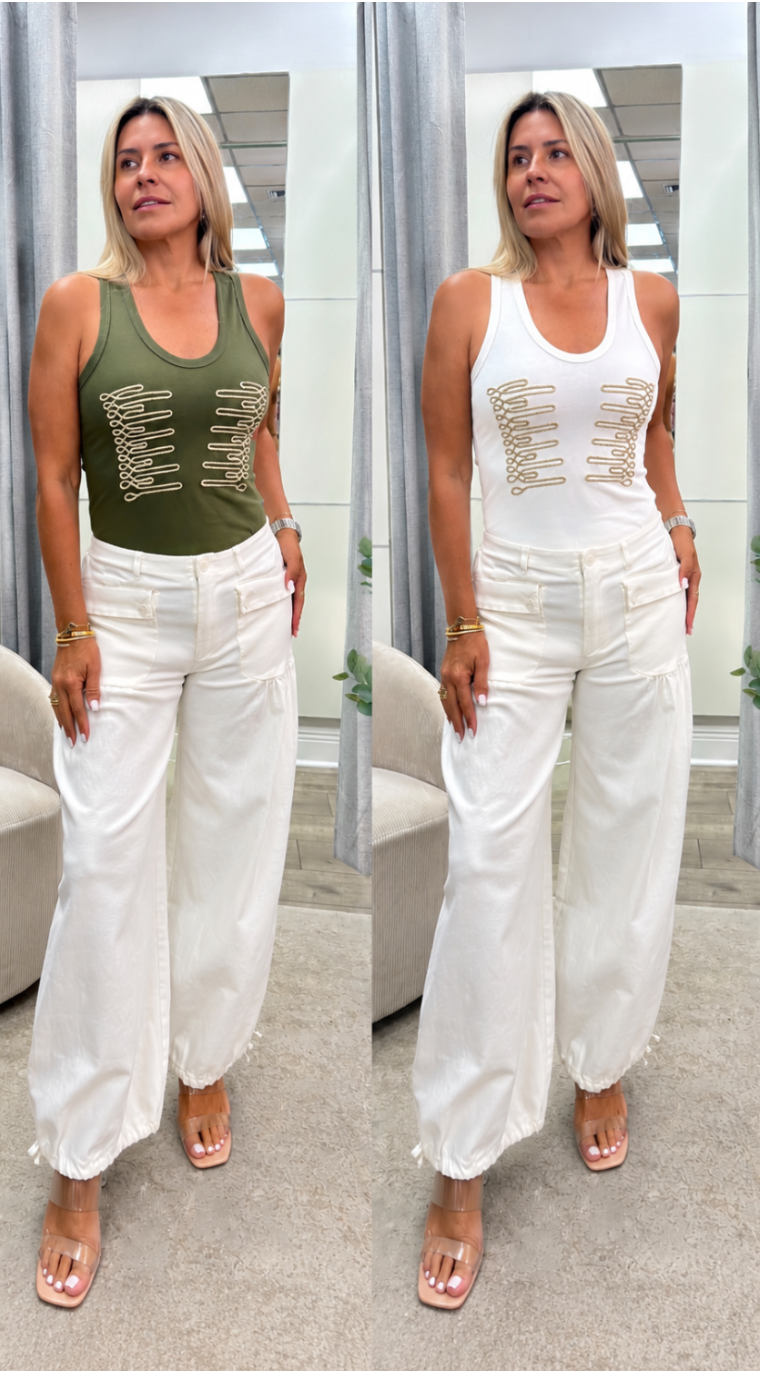 A side-by-side comparison of a woman modeling a sleeveless tank top with gold lace-up details. On the left, the top is olive green, and on the right, it is white.